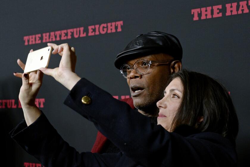 Actor Samuel L. Jackson, left, poses for a picture with producer Stacey Sher as they attend the premiere of 'The Hateful Eight' at ArcLight Cinemas Cinerama Dome in Hollywood.
