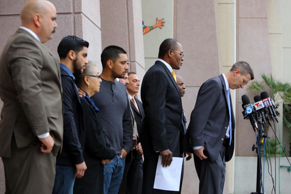 LAPD criminal gang homicide division detectives and family members gather at the LAPD's 77th Street station as officials announce the arrests of two suspects in the fatal robbery and stabbing of Maria Elena Rivas.