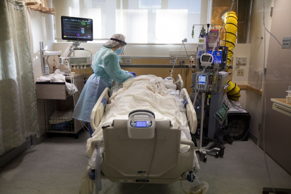 An ICU nurse treats a COVID-19-positive patient.