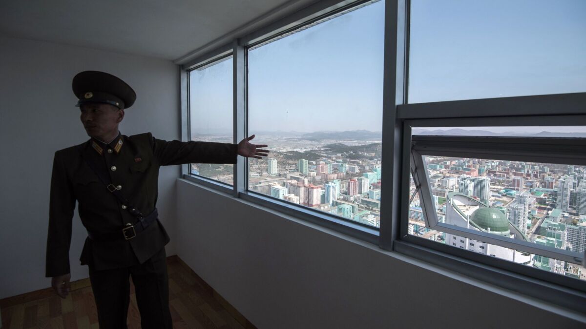 A Korean People's Army soldier shows off an apartment in the Ryomyong Street housing development in Pyongyang, North Korea.
