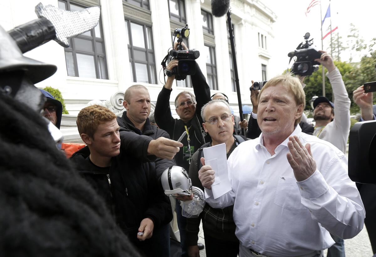 Raiders owner Mark Davis, right, speaks to fans and media outside the NFL's owners meetings in San Francisco.
