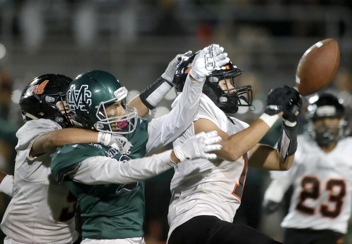 Costa Mesa's Kendrick Figueroa gets tangled up with Los Amigos defenders, including Isaac Cuevas (1).