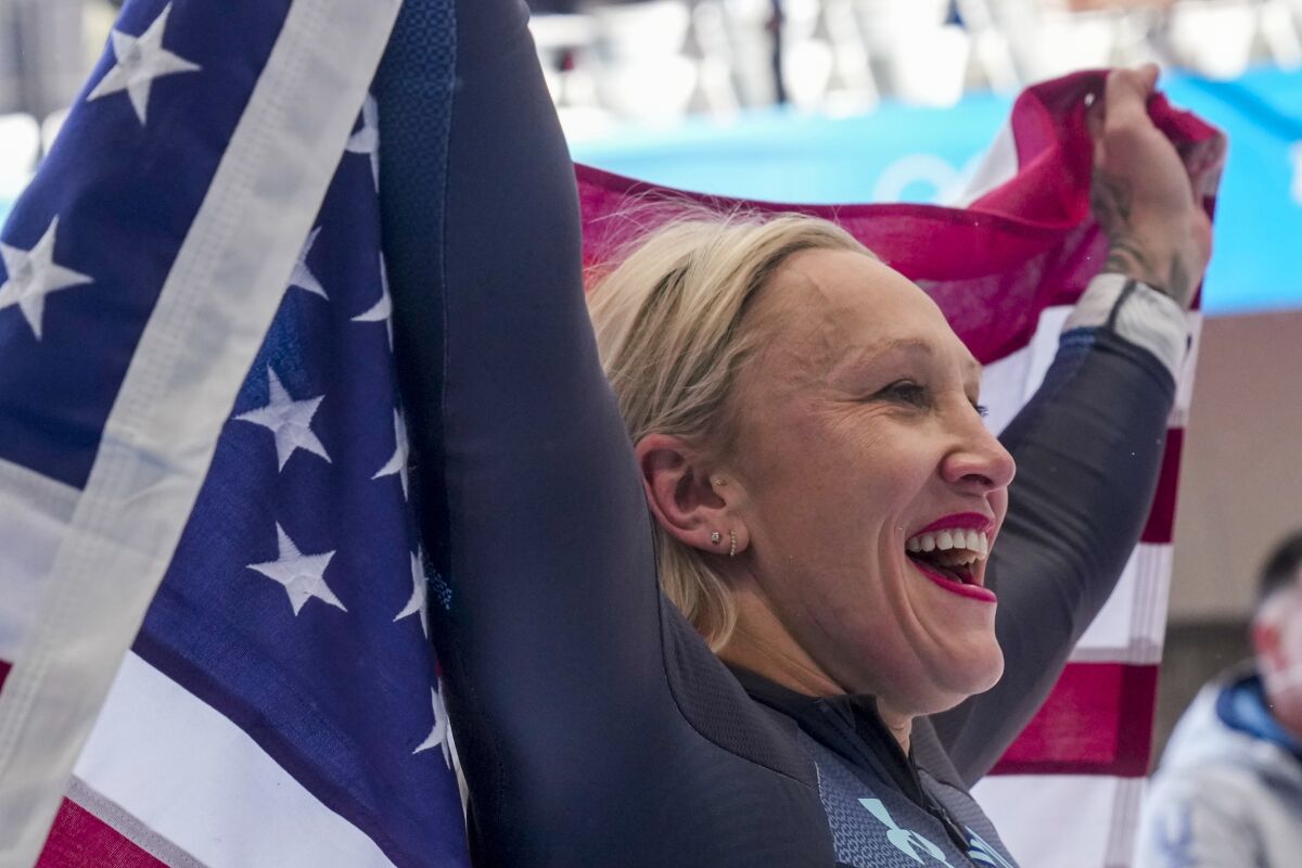 Kaillie Humphries, of the United States, celebrates winning the gold medal in the women's monobob at the 2022 Winter Olympics, Monday, Feb. 14, 2022, in the Yanqing district of Beijing. (AP Photo/Mark Schiefelbein)