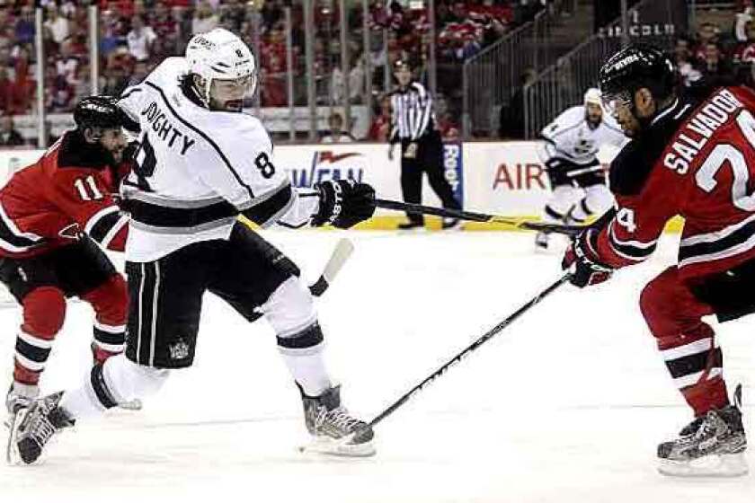 Kings defenseman Drew Doughty follows through on a shot that zipped past Devils defenseman Bryce Salvador and beat goaltender Martin Brodeur (not pictured) in the first period of Game 2 on Saturday evening at the Prudential Center in Newark, N.J.