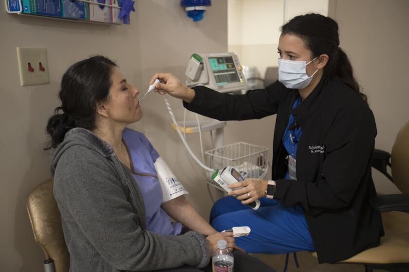 Allen J. Schaben  Los Angeles Times Nurse Marenna Bielman takes Angelica Lara’s blood pressure as she is treated for flu-like symptoms last year at St. Joseph’s Hospital in Orange.