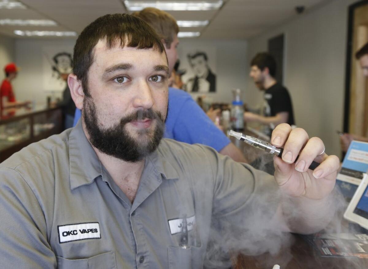 John Durst demonstrates the use of an electronic cigarette at his shop in Oklahoma City. Marlboro maker Altria Group Inc. said Thursday it is rolling out an electronic cigarette.