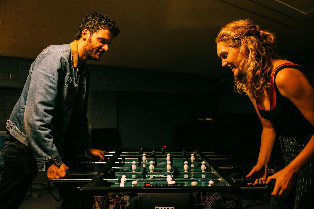 A man and a woman playing foosball. 
