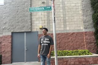 Heisman Trophy winner Bryce Young poses under the updated Heisman Lane sign at Mater Dei.
