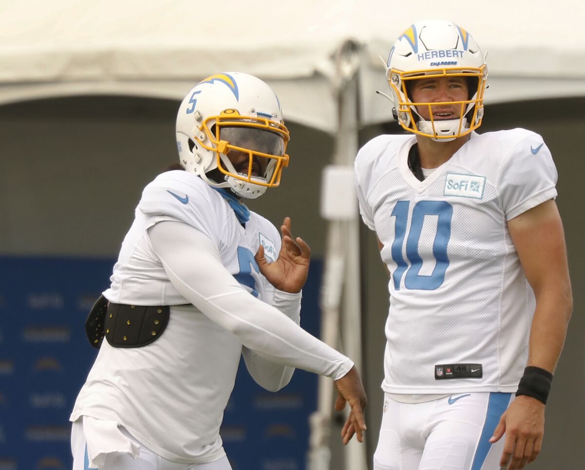 Chargers quarterbacks Justin Herbert, right, and Tyrod Taylor on the field during practice Aug. 19 in Costa Mesa.
