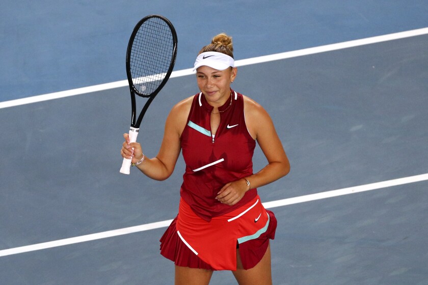 Tennis player Amanda Anisimova raising her racquet