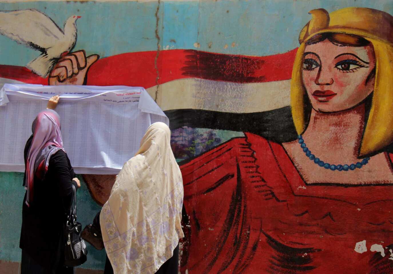 Egyptian women check for their names in the voters list before casting their ballots in the first round of presidential elections at a polling station in Cairo.