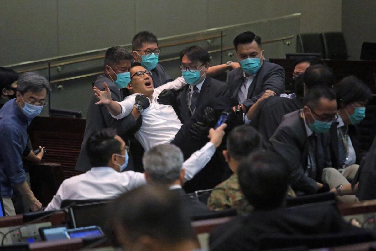 Lam Cheuk-ting, a pan-democratic legislator in Hong Kong, is taken away by security during a meeting by the legislature’s House Committee on Monday.