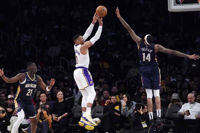 Lakers guard Russell Westbrook, center, shoots as New Orleans Pelicans Brandon Ingram, right, and forward Tony Snell defend