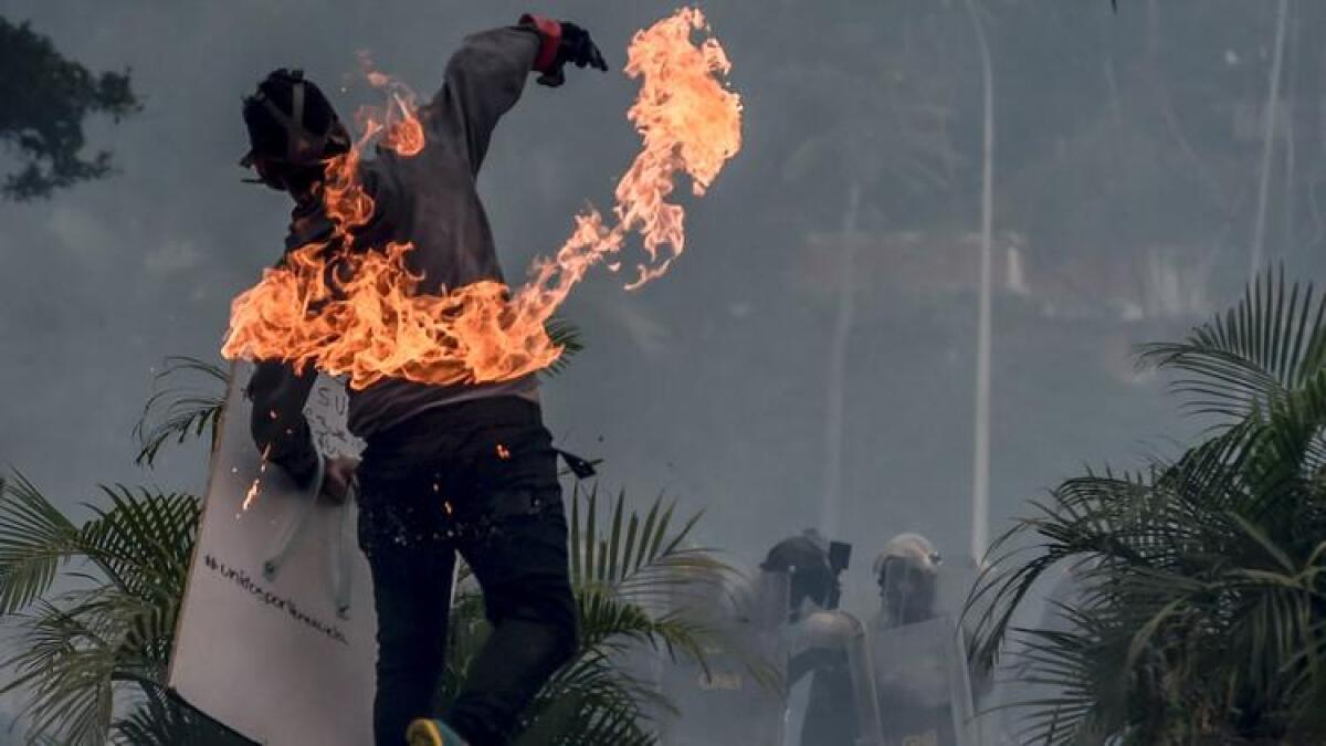 A demonstrator clashes with police in Caracas