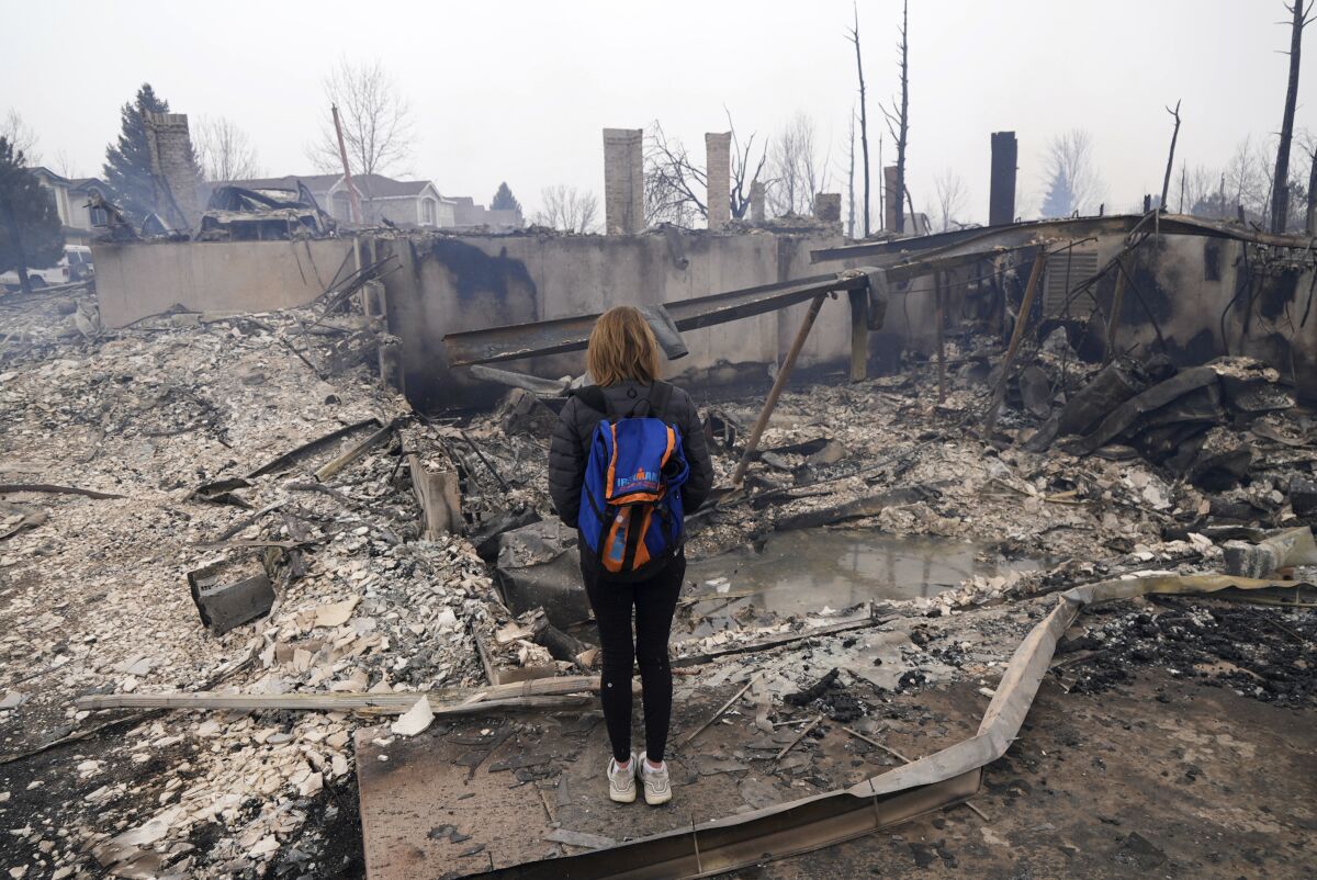Cathy Glaab surveys the charred remains of her home.
