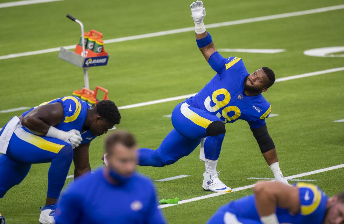The Rams' Aaron Donald (99) stretches before a team scrimmage on SoFi Stadium.