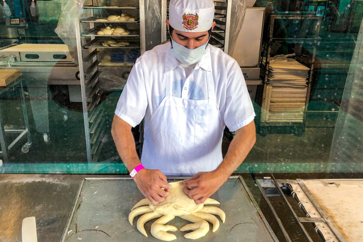 A baker at work crafts bread dough into the shape of a crab at Boudin Bakery 
