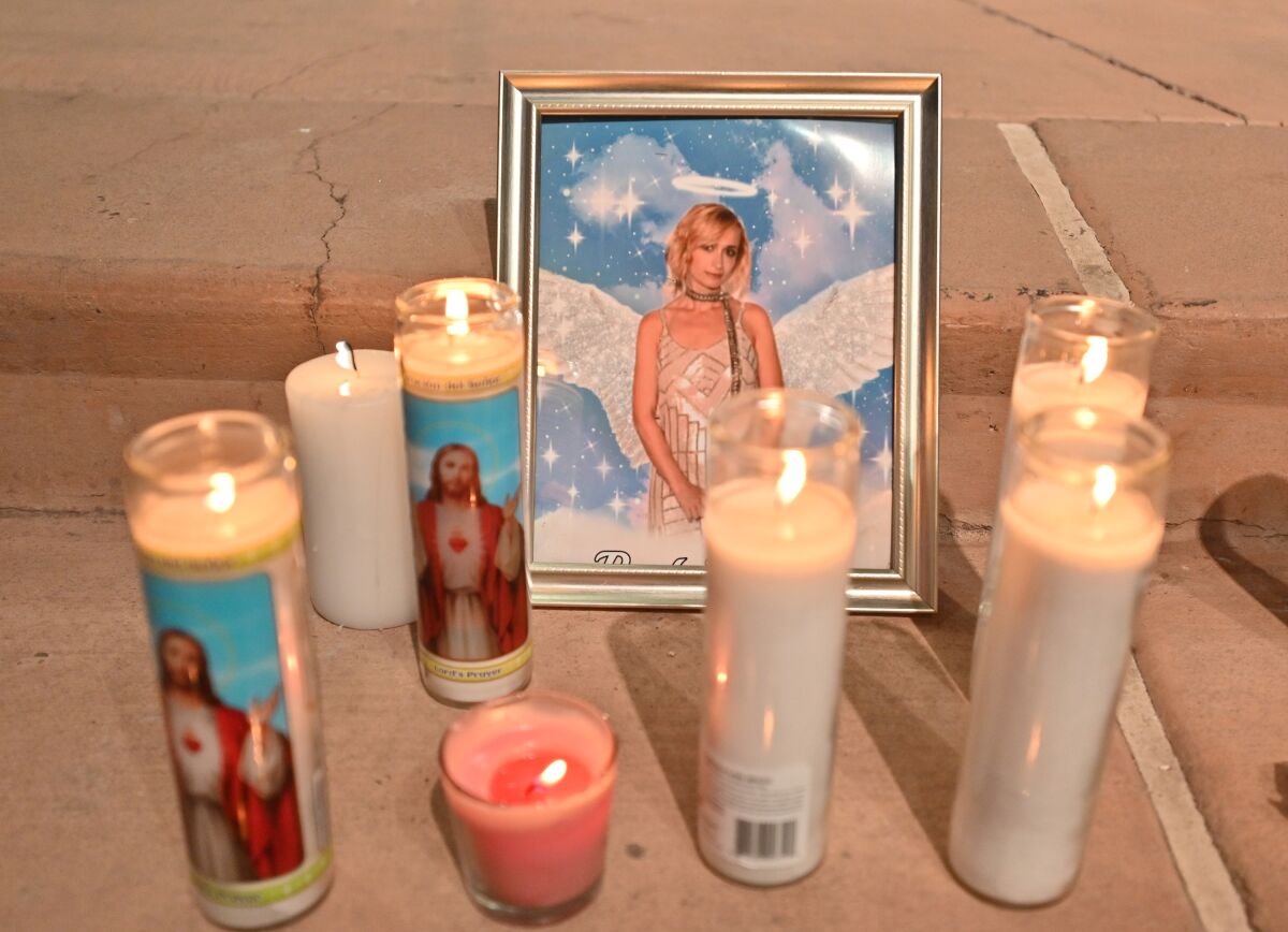 Candles are placed around a photo of cinematographer Halyna Hutchins during a vigil