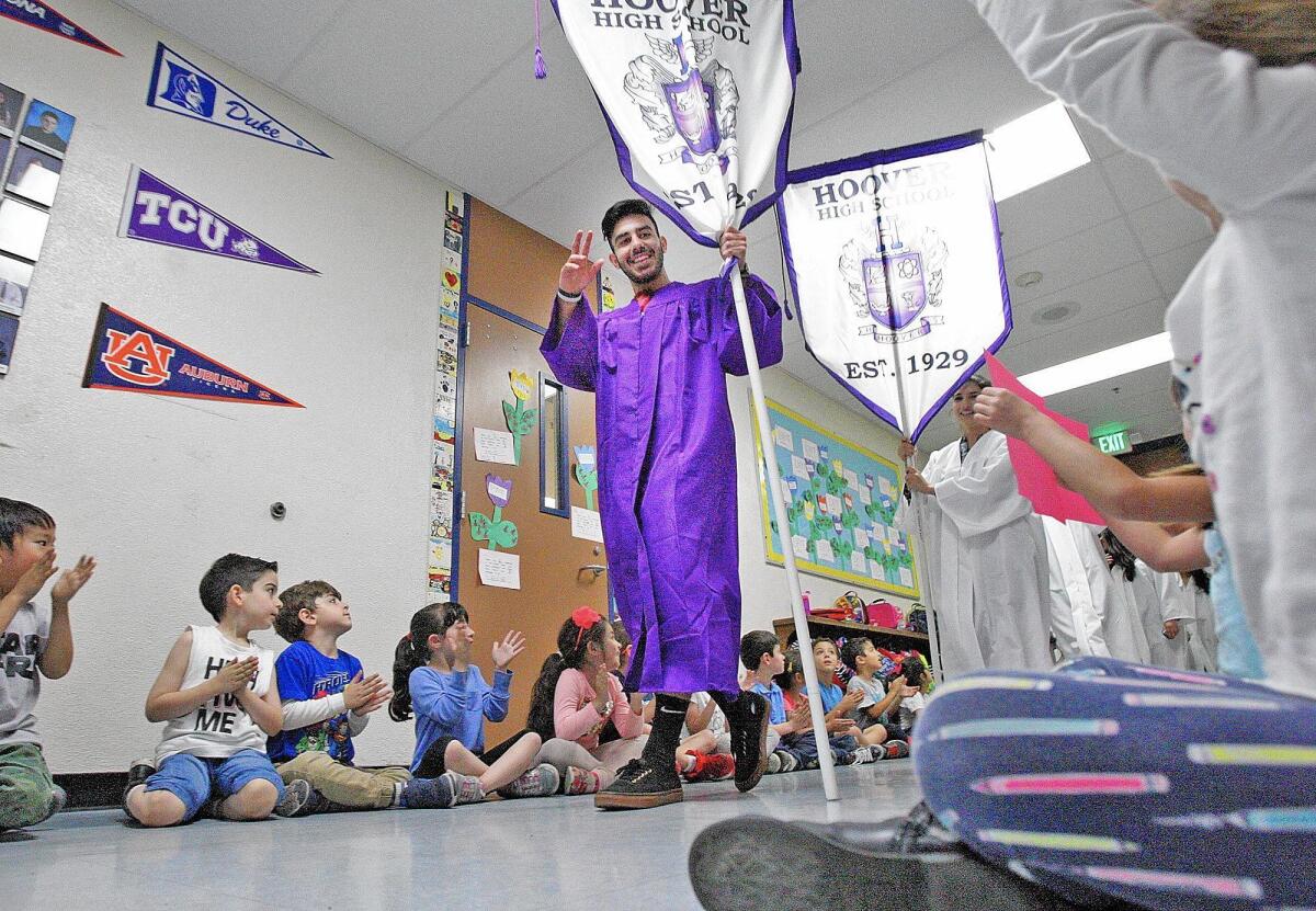 Hoover High School senior Ara Sukiasyan waves to Mark Keppel Elementary School students. Inspired by social media, seniors from Hoover visited Keppel and Toll to encourage the younger students with the power of graduation gowns being worn by students from the 2016 graduating class.