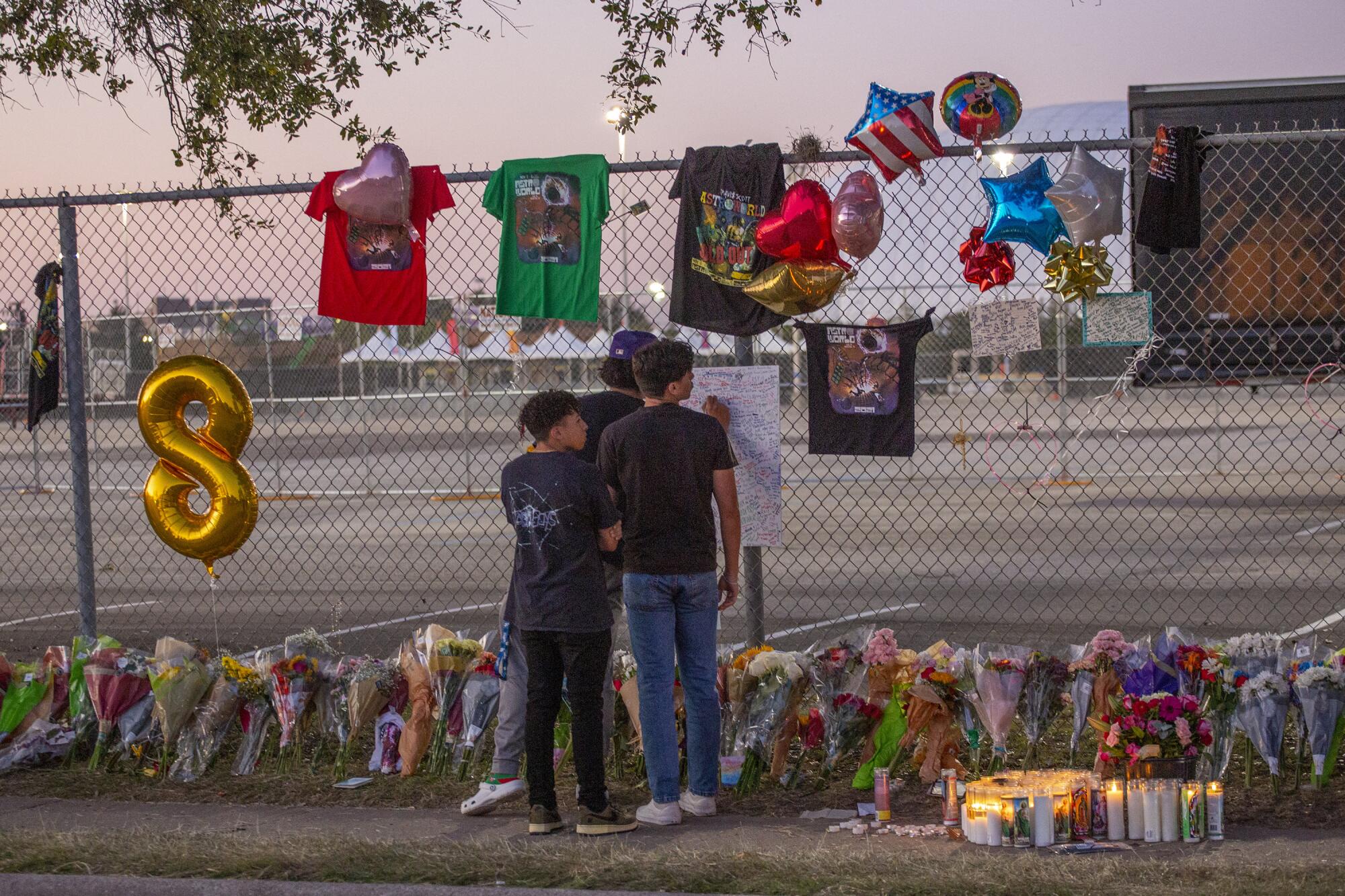 Teenagers sign a remembrance board at a memorial site in Houston.