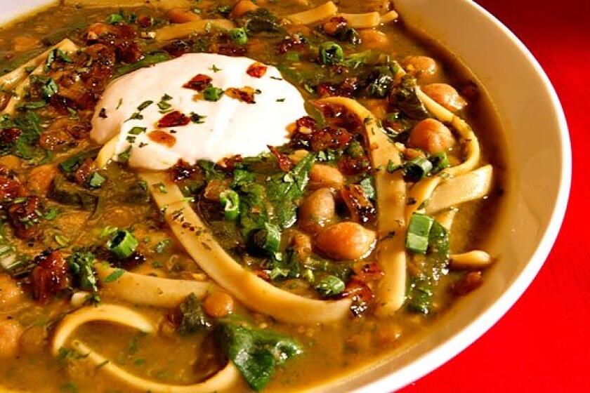 Chickpea and noodle soup with spinach, Persian herbs and kashk topping