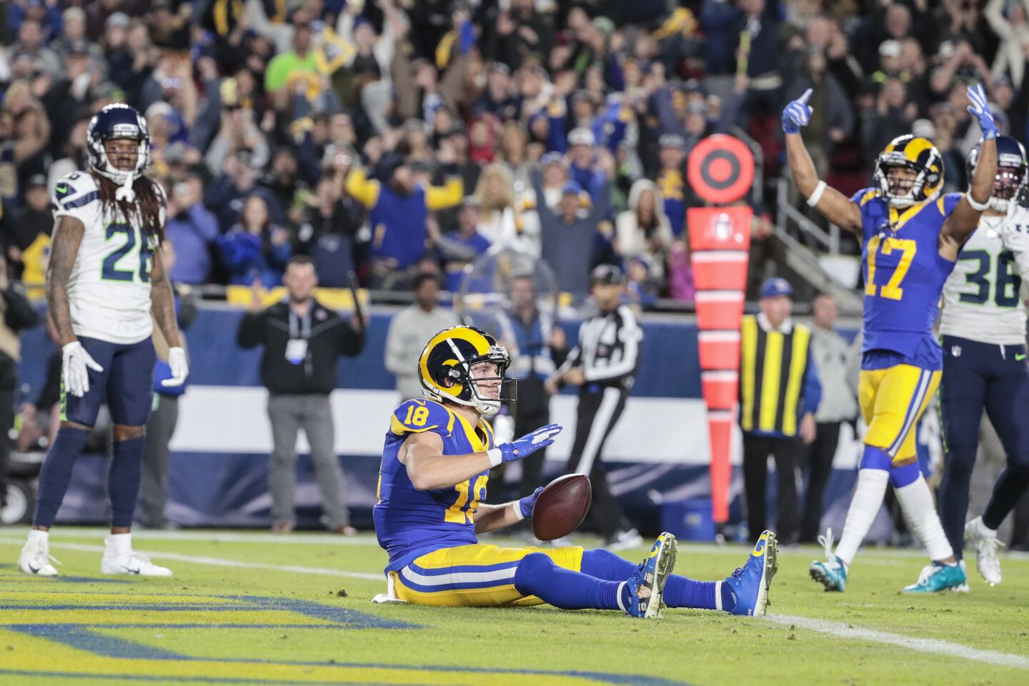 Rams wide receiver Cooper Kupp sits in the end zone after catching a touchdown pass.