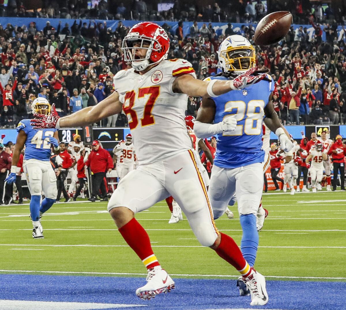 Kansas City tight end Travis Kelce scores a touchdown in overtime in front of Chargers cornerback Davontae Harris.