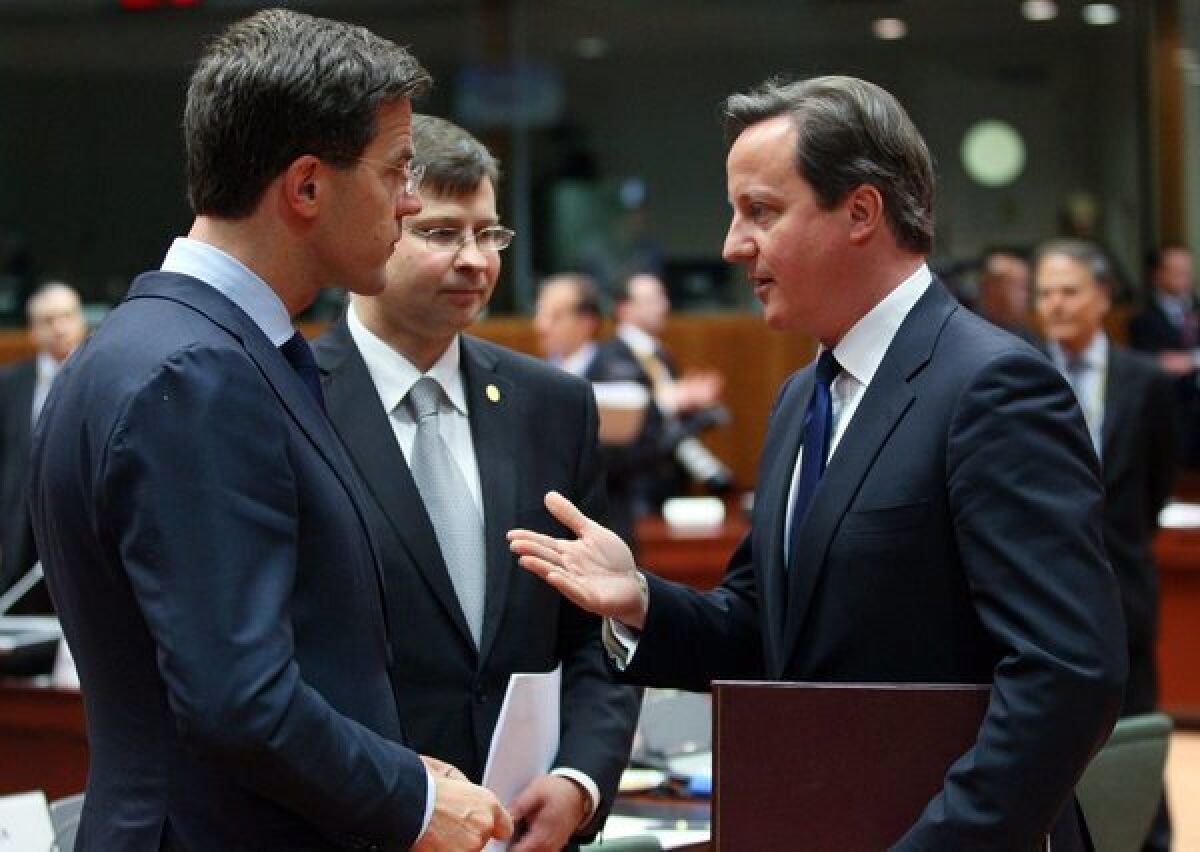 From left, Dutch Prime Minister Mark Rutte, Latvian Prime Minister Valdis Dombrovskis and British Prime Minister David Cameron chat during a European Council summit in Brussels.