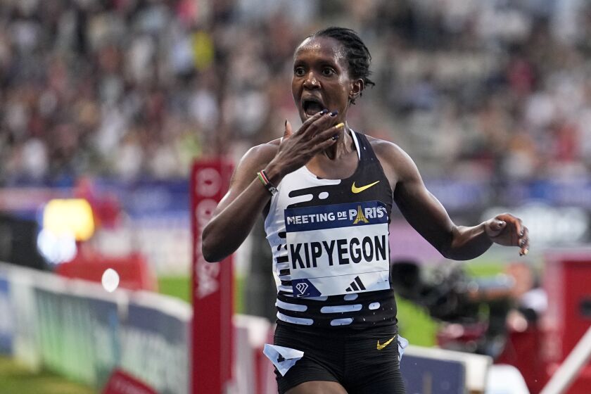 Faith Kipyegon, of Kenya, crosses the finish line to win the Women 5000 meters setting a new world record during the Meeting de Paris Diamond League athletics meet in Paris, Friday, June 9, 2023. (AP Photo/Michel Euler)