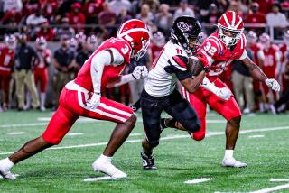 Linebackers Nasir Wyatt (left) and Abduall Sanders of Mater Dei prepare to take down Corona Centennial's Tyler George.