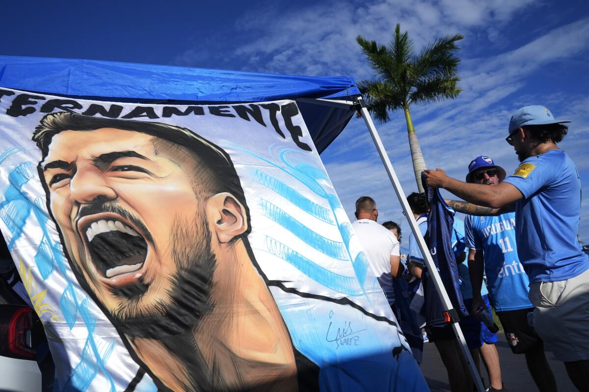 Hinchas uruguayos muestran una manta con la imagen del delantero Luis Suárez 