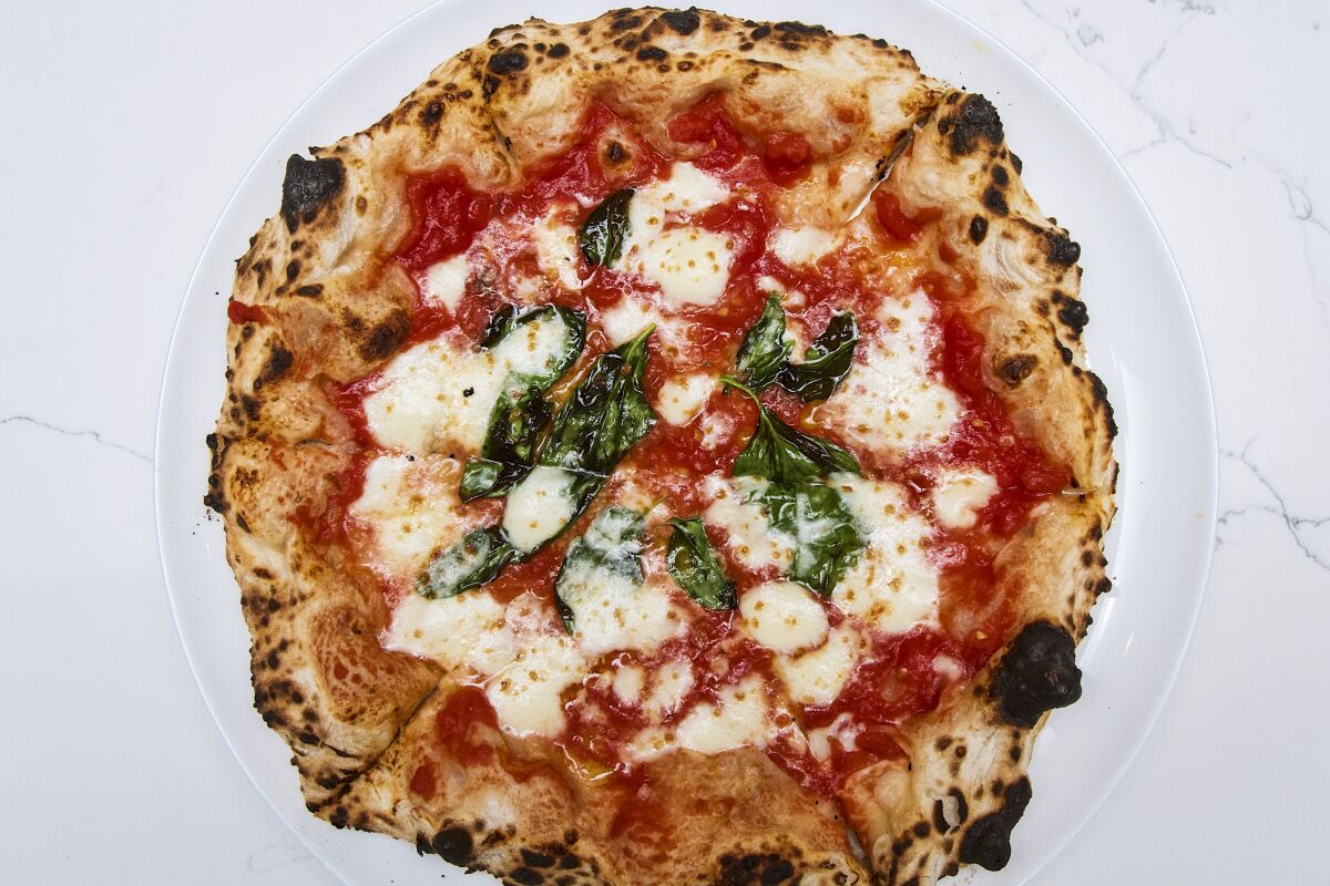 An overhead photo of a glossy Margherita pizza from Pizzeria Sei.