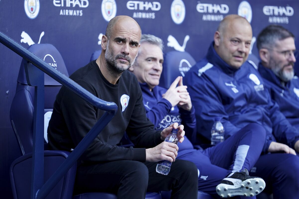Manchester City's head coach Pep Guardiola, left, watches the players before the start of the English Premier League soccer match between Manchester City and Newcastle United at Etihad stadium in Manchester, England, Sunday, May 8, 2022. (AP Photo/Jon Super)