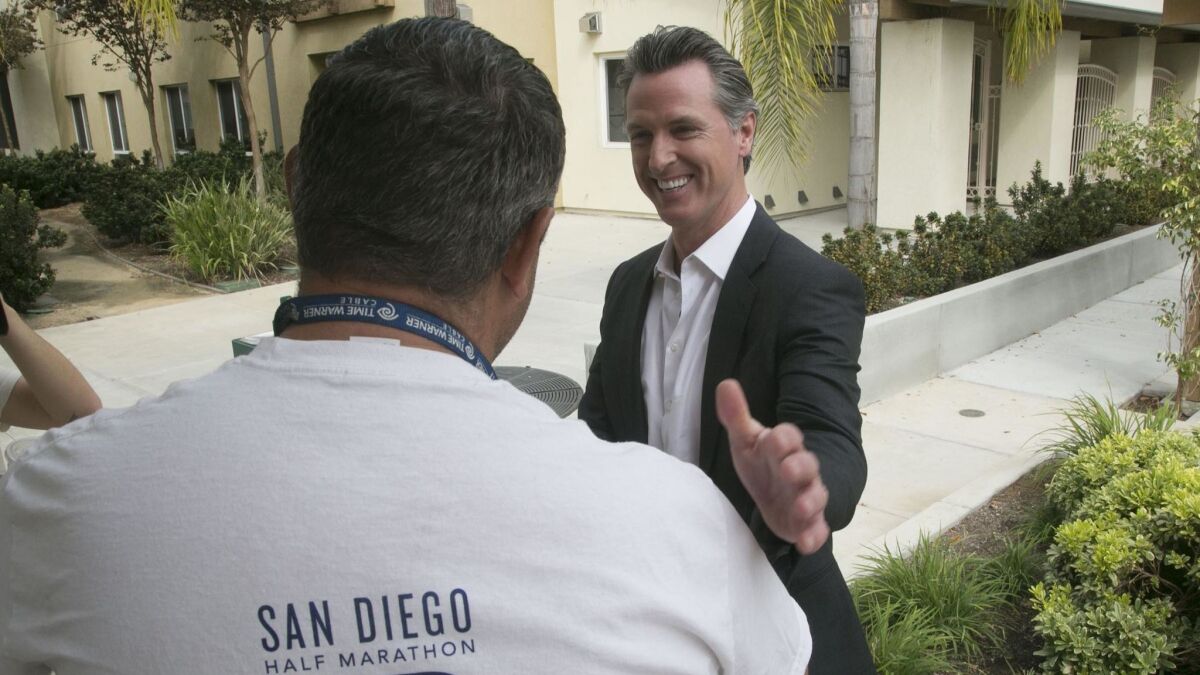 California Lt. Governor Gavin Newson, the Democratic candidate for Governor, spoke with Michael Murray, a client at the Veterans Village of San Diego during a campaign stop on Friday.