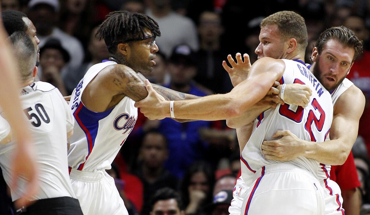 Clippers power forward Blake Griffin (32) is separated from Jazz forward Trevor Booker (left), who committed a hard foul, by referee Olandis Poole (50) as well as Clippers teammate Chris Douglas-Roberts (center) and Spencer Hawes in the second half.