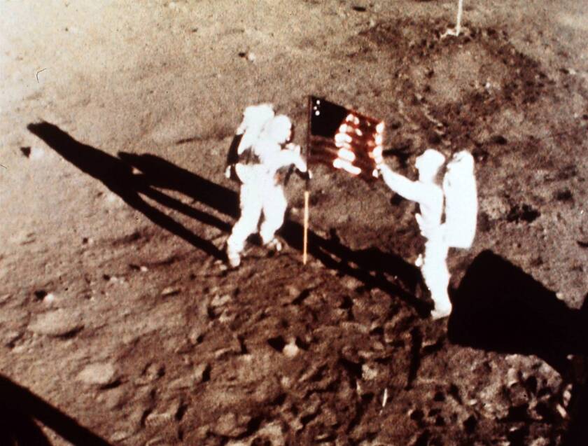 Apollo 11 astronauts Neil Armstrong and Edwin E. "Buzz" Aldrin, the first men to land on the moon, plant the U.S. flag on the lunar surface.