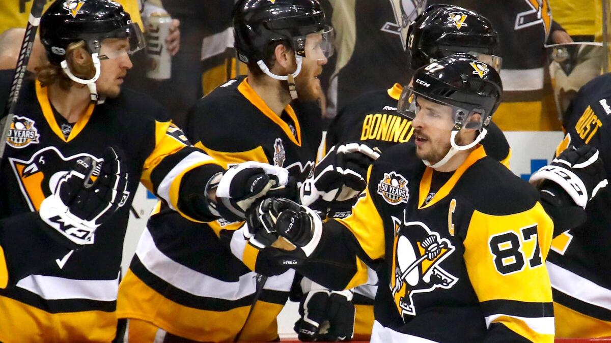 Penguins center Sidney Crosby (87) celebrates with teammates after scoring a goal during the first period Sunday.