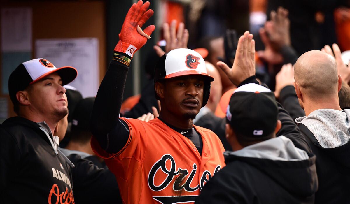 Orioles center fielder Adam Jones is congratulated by teammates after hitting a two-run home run against the Royals in Game 2 of the ALCS on Saturday.