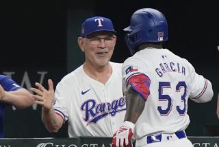 Bruce Bochy, manager de los Rangers de Texas, felicita al cubano Adolis García, luego que conectó un jonrón en el duelo del miércoles 15 de mayo de 2024, ante los Guardianes de Cleveland (AP Foto/LM Otero)