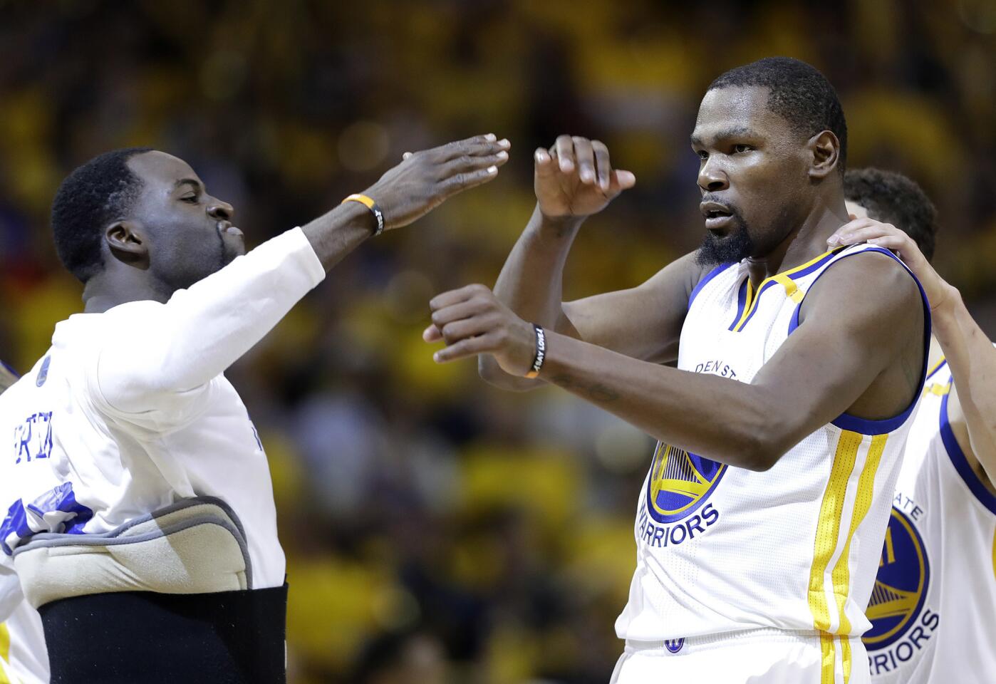 Warriors forward Kevin Durant, center, celebrates with Draymond Green, left, and Klay Thompson during the second half.