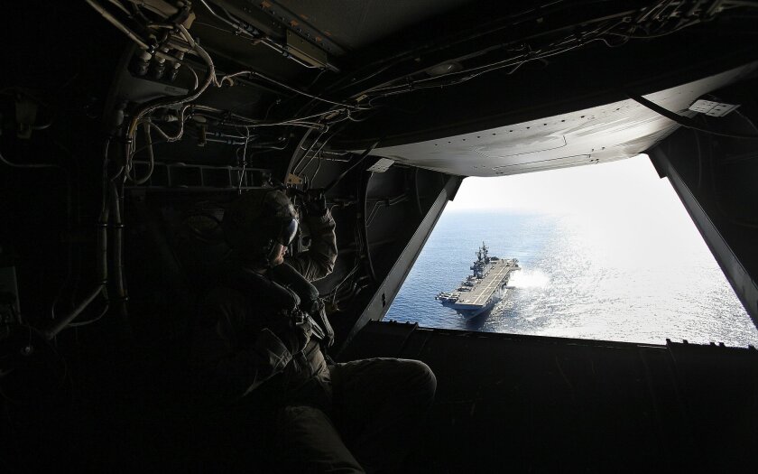 Dawn Blitz 2015, a multinational amphibious training exercise is being conducted on and off Camp Pendleton,Naval Base San Diego and a MCAGCT at Twenty-nine Palms, CA. involving US forces, Japan, New Zealand and Mexico. Marine Cpl Logan Horne, crew chief aboard a SV-22 Osprey, watches the USS Boxer (LHD4) through the rear hatch on its way to the Japanese Maritime Self Defense Force Ship JDS Hyuga (DDH 181)