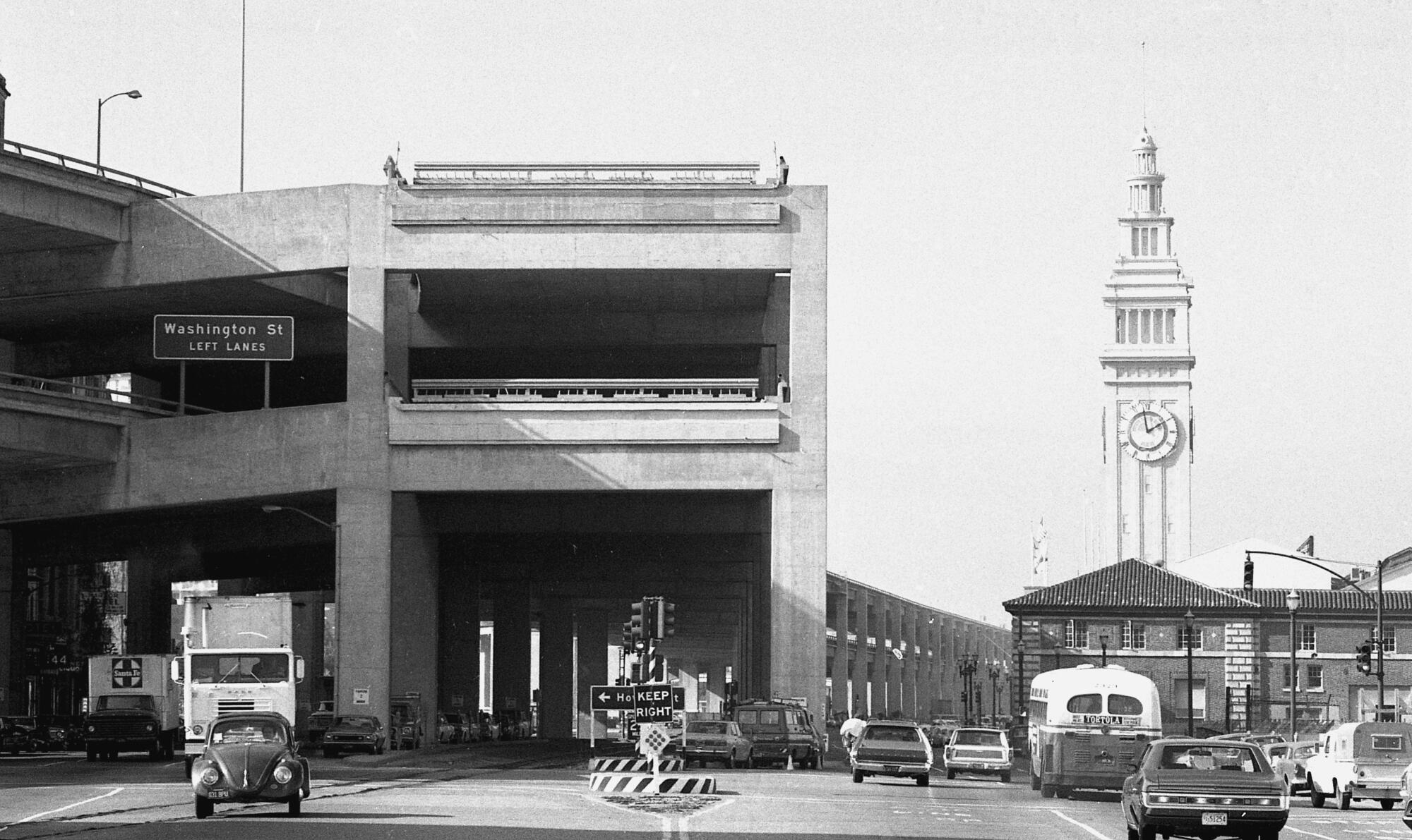 A double-decker freeway runs past the Ferry Building in a black-and-white photo