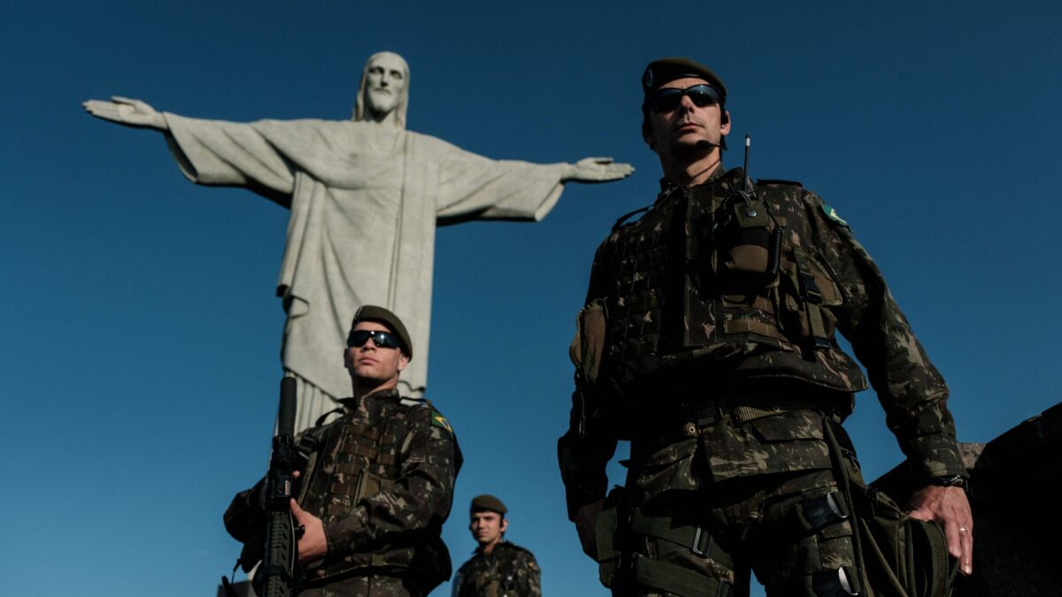 Brazlian army personnel patrol in front of the statue of Christ the Redeemer atop Corcovado Hill in Rio de Janeiro