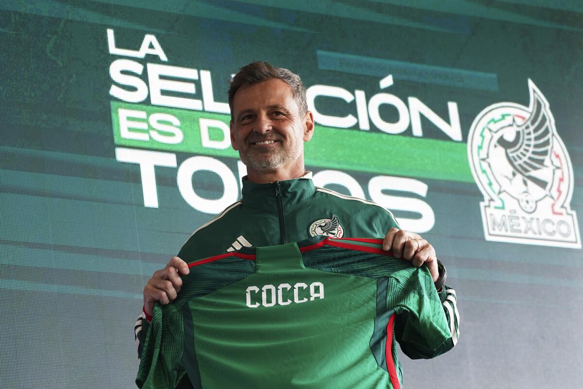 Diego Cocca holds up a jersey during his first news conference as Mexico's new coach