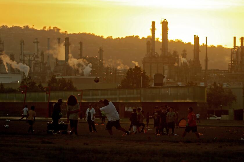 LOS ANGELES, CALIF. - OCT. 4, 2022. Youth soccer teams practice at Wilmington Waterfront Park in the shadow of the Conoco Phillips refinery. (Luis Sinco / Los Angeles Times)