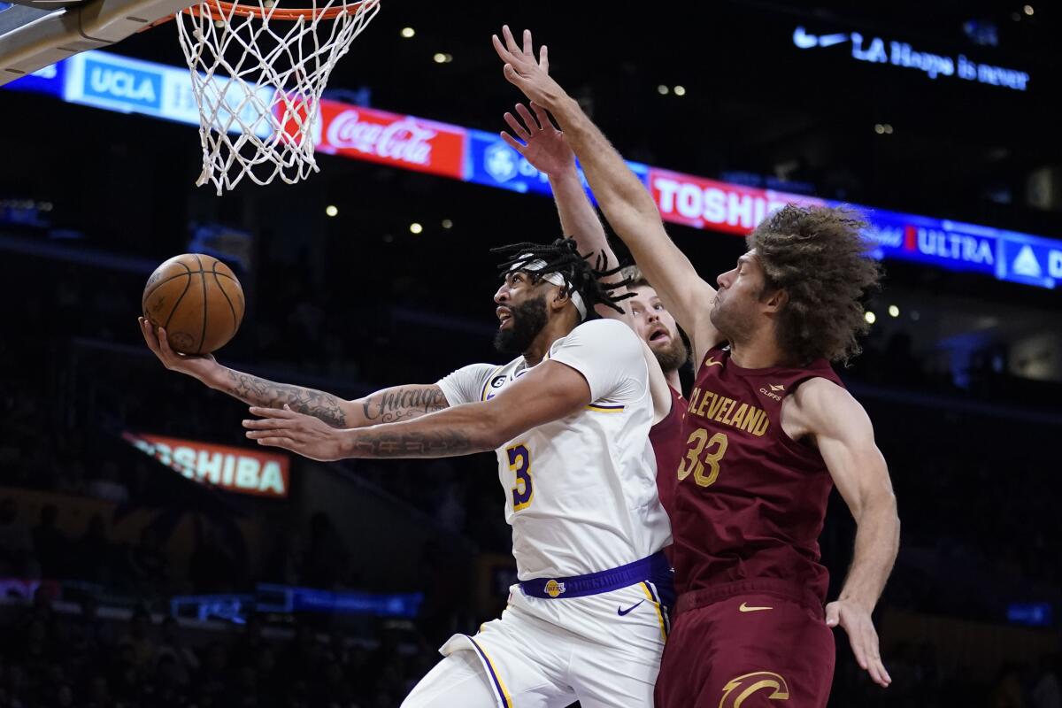 Lakers forward Anthony Davis attempts a layup while Cavaliers center Robin Lopez tries to block the shot.