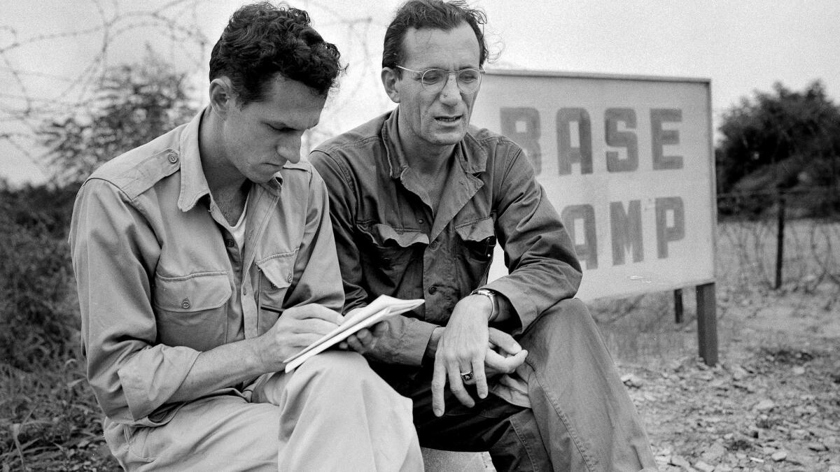 Sam Summerlin, left, interviews Robert J. Santucci, a United Nations civilian stenographer, outside the entrance to the base camp at Munsan, Korea, in 1951.