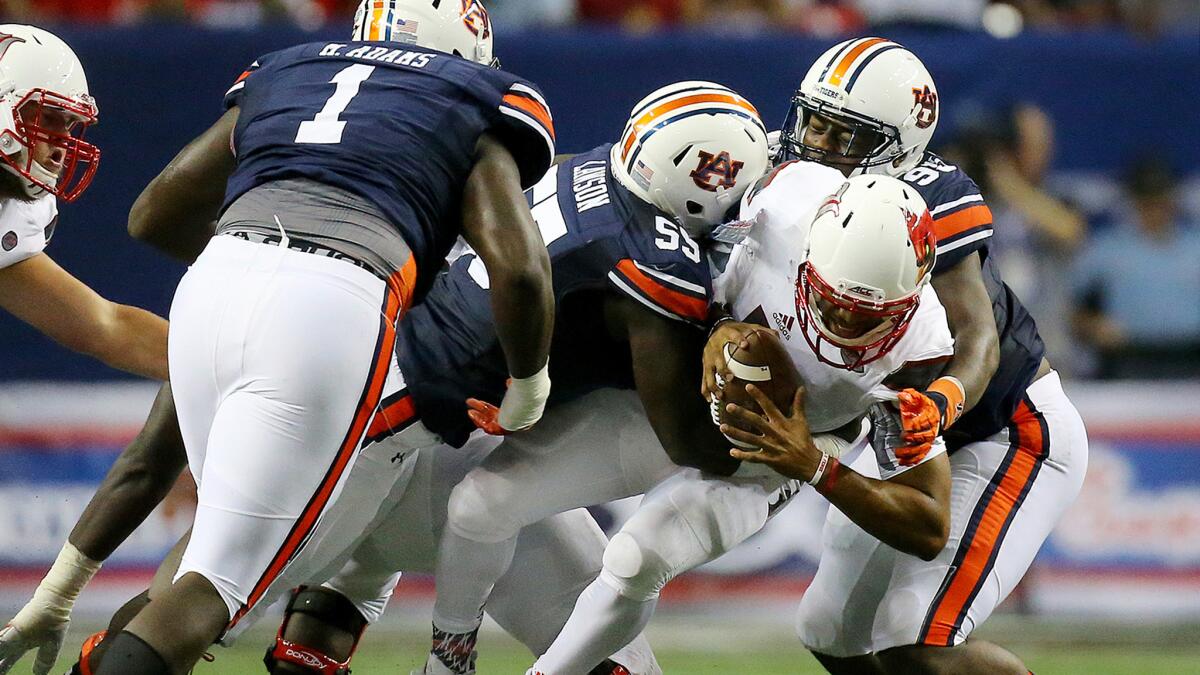 Louisville quarterback Reggie Bonnafon is sacked by Auburn defenders Carl Lawson (center) and Dontavius Russell (right) in the second quarter Saturday.