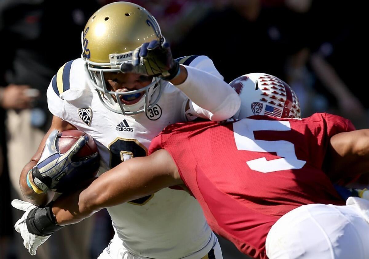 UCLA receiver Jordan Payton fights for extra yardage against Stanford cornerback Devon Carrington on Oct. 19.