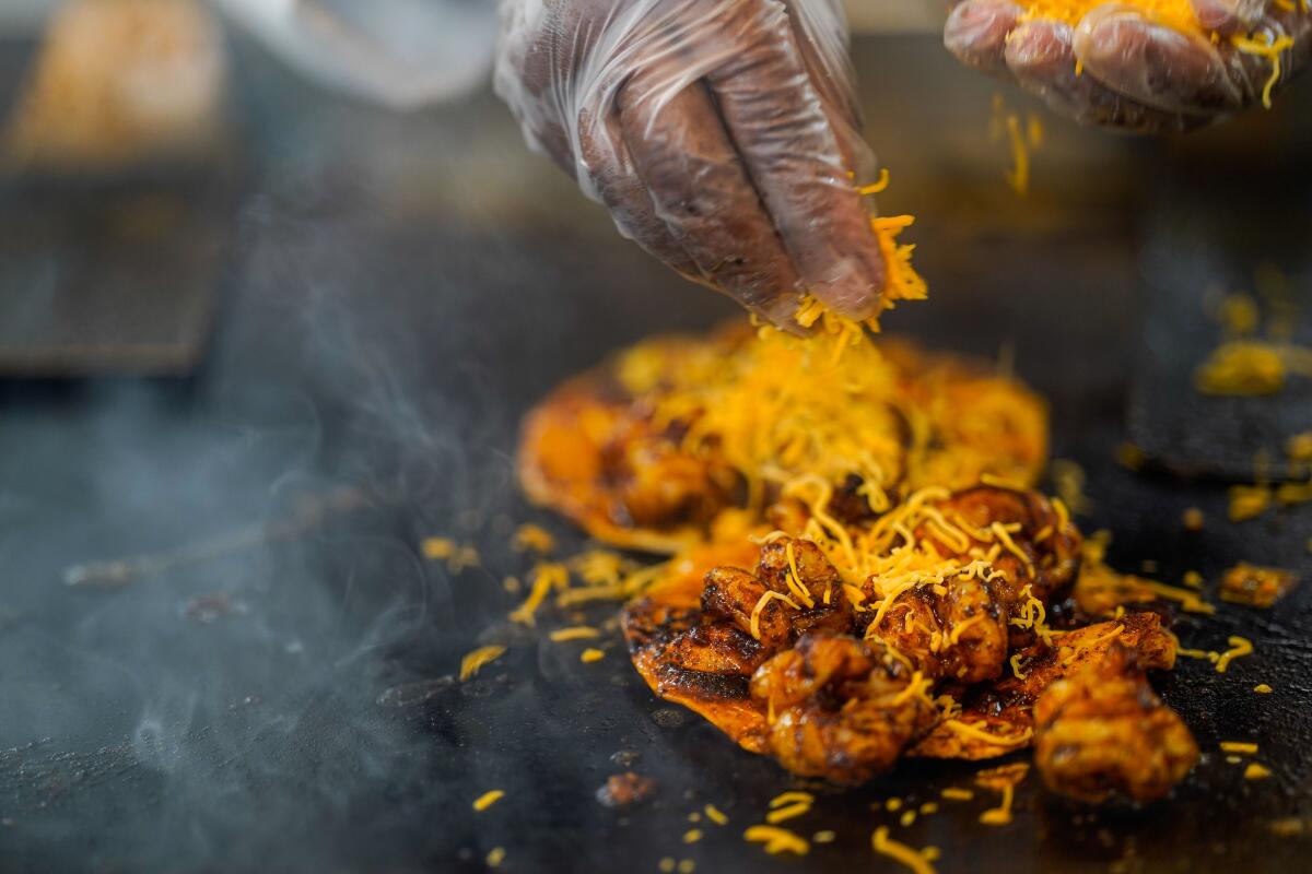 Barbara Burrell in the kitchen, prepares two shrimp tacos